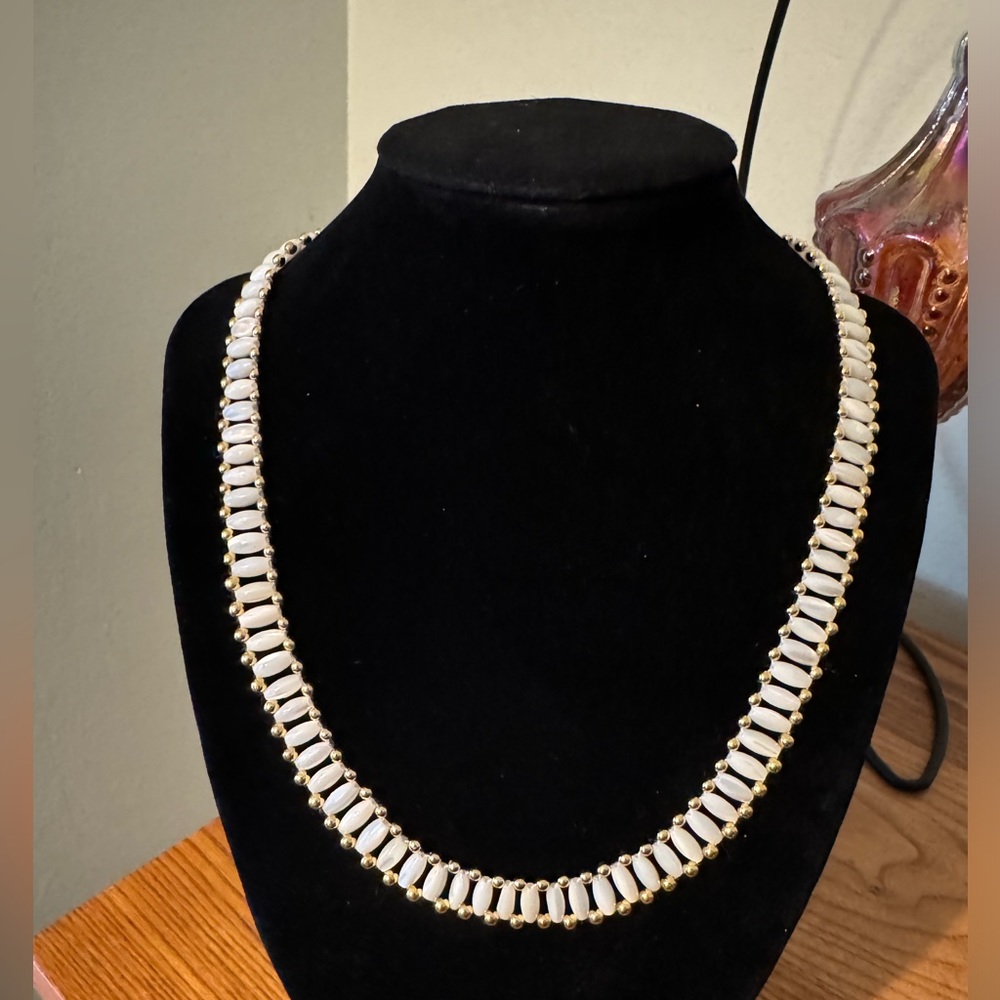 EUC necklace. Shimmery white beads in gold setting. Screw closure.